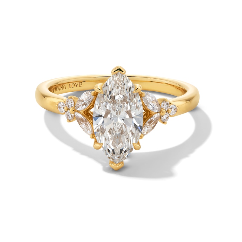 Gold-tone ring with a marquise-shaped clear center stone and smaller side stones on a white background.
